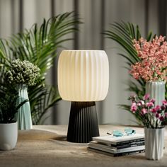 a table topped with vases filled with flowers next to a book and planter