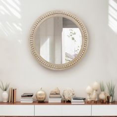 there is a mirror on the wall next to some vases and other items in front of it