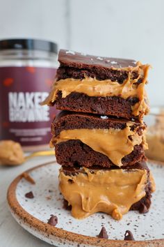 three brownies stacked on top of each other with peanut butter drizzled on them