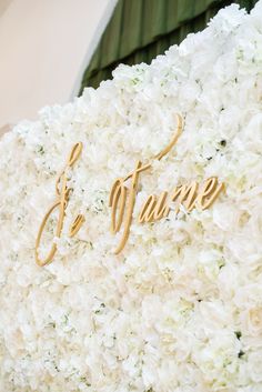 white flowers and gold lettering on the side of a building