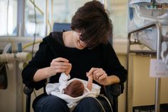 a woman sitting in a chair holding a baby