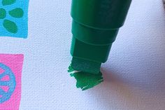 a green crayon marker on top of a piece of paper