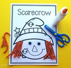 a scarecrow craft with scissors and thread on a yellow background, next to it is an orange crayon marker