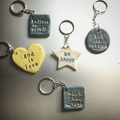 four different key chains with words on them and a star in the shape of a heart