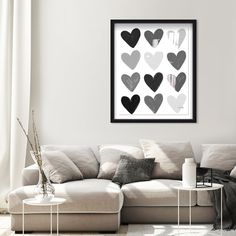 a living room with a white couch and black hearts on the wall