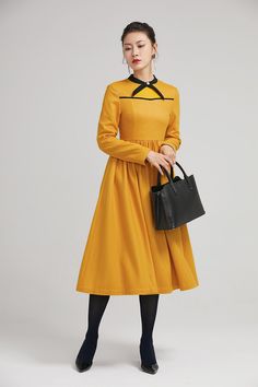 "Formal yellow wool dress with fully polyester Lining. Neck has black tie, tucks at shoulders front and back with a button decoration. Details: * yellow wool fabric with polyester lining * round collar * two seam pockets * pleating details * back zipper closure * long sleeves * mid calf length * button decoration on the neckline SIZE GUIDE Size vary between Brand and Country Please get your body measurement with our Size Guide And Find your size in our Size Chart Size Guide & Chart https://e Long Sleeve Wool Dresses For Office, Office Wool Dresses With Long Sleeves, Formal Yellow Dress For Fall, Yellow Midi Dress For Fall Evening Events, Yellow Midi Dress For Fall, Yellow A-line Midi Dress For Work, Flare Dress Formal, Fit And Flare Dress Formal, Winter Wool Dress