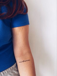 a woman's arm with a small tattoo on the left side of her arm