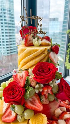 a multi layered cake decorated with fruit and flowers