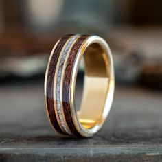 a wedding ring with wood and gold inlays on the inside, sitting on top of a table