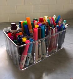 a plastic container filled with lots of different colored pens