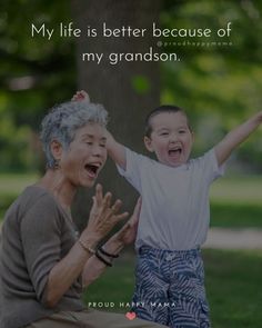 an older woman and young boy sitting in the grass with their hands up to each other