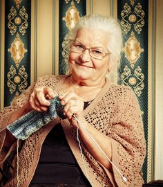 an older woman is knitting with her hands