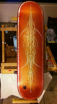 an orange skateboard sitting on top of a wooden stand