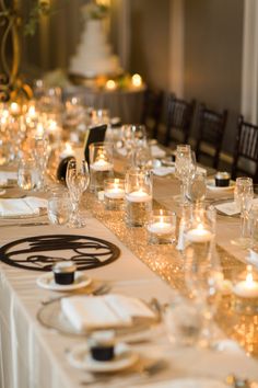 a long table is set up with candles and place settings for an elegant dinner party