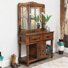 a mirror sitting on top of a wooden table next to a vase filled with flowers