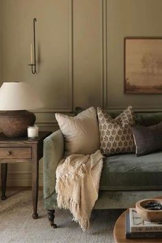 a living room filled with furniture and pillows on top of a couch next to a table