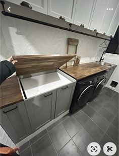 a kitchen with white cabinets and wood counter tops