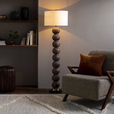 a living room with a chair, lamp and bookshelf