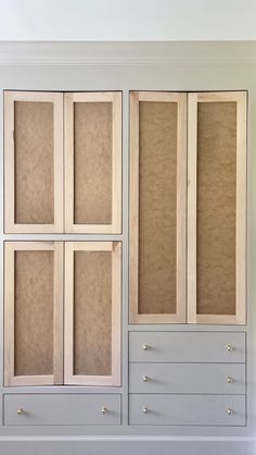 an empty white cabinet with drawers and doors