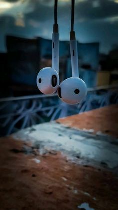 two earphones hanging from the ceiling in front of a cityscape at night