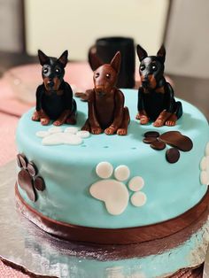 two dogs on top of a blue cake with paw prints