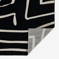 a black and white rug with an abstract design on the bottom, in front of a gray background