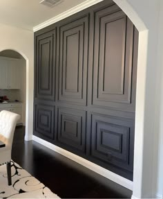 a living room with dark wood paneling and white furniture