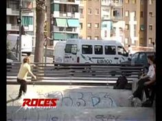 a man riding a skateboard down the side of a cement ramp in a city