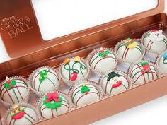 a box filled with lots of white chocolates covered in frosting and decorated like snowmen