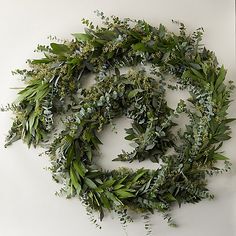 a wreath made out of green leaves and greenery