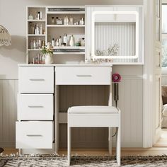 a white desk with drawers and a mirror above it in a room that has a rug on the floor