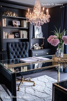 a living room with a couch, desk and chandelier