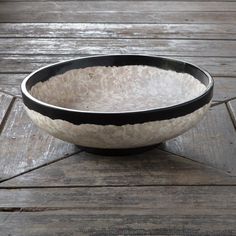 a black and white bowl sitting on top of a wooden table