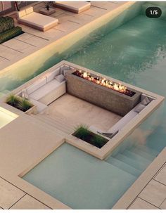 an outdoor fire pit in the middle of a swimming pool