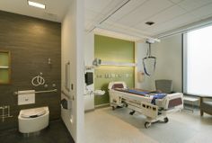 a hospital room with a bed, chair and shower stall in it's corner