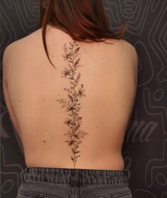 the back of a woman's body with flowers on her upper and lower back