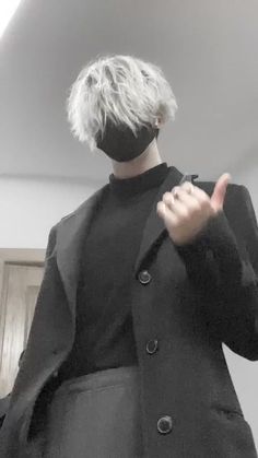 a person with white hair wearing a black jacket and holding their hand up to the side