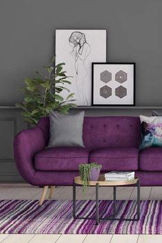 a living room with a purple couch and some pictures on the wall above it, along with a coffee table