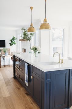 a kitchen island with two hanging lights above it