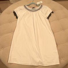 Brand New - Vineyard Vine White Cotton Dress With Cap Sleeves With Black Tassel, Round Neck Line With Black Detail - Size Medium- New With Tags Casual White Dresses With Tassel Ties, Casual White Dress With Tassel Ties, Casual White Dress With Tassels, Casual White Tassel Dress, White Summer Dress With Tassel Ties, Summer White Dresses With Tassel Ties, White Tassel Mini Dress For Beach, White Mini Dress With Tassels For Beach, Chic White Tassel Dress