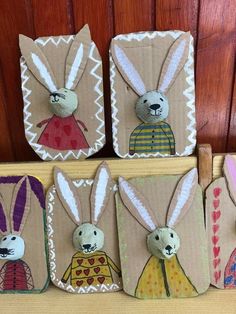 four little bunny magnets are sitting on a shelf next to some wood planks