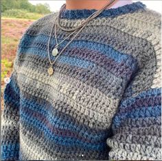 a close up of a person wearing a sweater with a necklace on it's neck