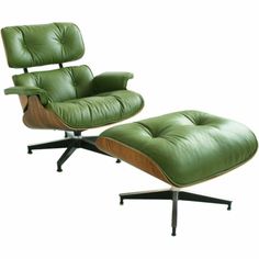 an eames lounge chair and ottoman with green leather upholstered on the back