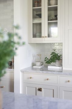 a kitchen with white cabinets and marble counter tops is featured in the instagram post