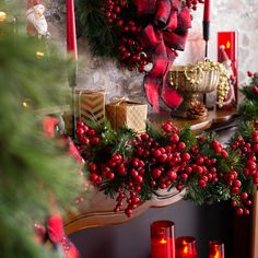 a christmas mantle with candles and wreaths on it