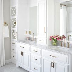 a white bathroom with two sinks and mirrors