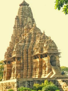 an ornately carved building with trees in the foreground