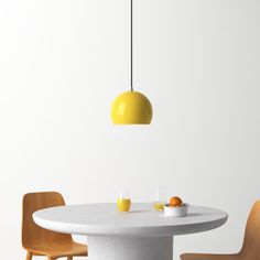 a white table with two chairs and a yellow light hanging over it