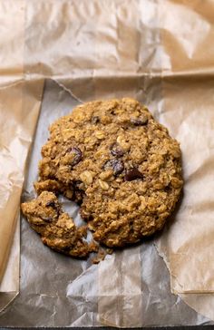 an oatmeal cookie sitting on top of a piece of waxed paper