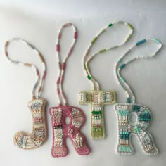 three beaded letters are hanging on a string